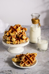 Breakfast scene with Croffle waffles served on plates, accompanied by a sealed milk bottle and filled glass.