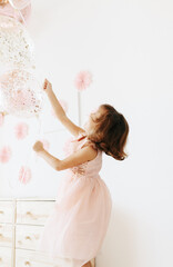 Little girl wearing pink dress with balloons. Styled home birthday party