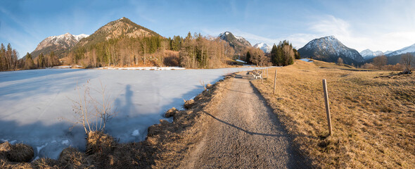 moor lake Oberstdorf with frozen surface, allgau alps in march, walkway with stunning views