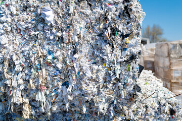 Shallow focus of the front of a fresh shredded bale of business papers and used stationary. Shown...