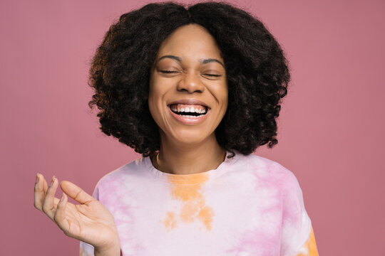 Authentic Portrait Of Beautiful Smiling African Woman Wearing Stylish Tie Dye T Shirt Isolated On Pink Background. Positive Lifestyle