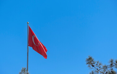 Turkish flag waving in the blue sky. Flagpole. 