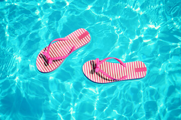 Flip flops in blue swimming pool