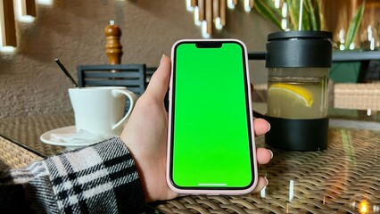 Woman's Hand Holding A Mobile Telephone With A Vertical Green Screen In Tram Mobile Phone Smartphone Telephone Green Screen Monitor For Internet. High quality photo