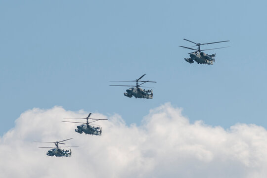 Russia, Sevastopol - July 23, 2021: Group of Russian two-seat attack helicopters Kamov Ka-52 `Alligator` NATO reporting name: Hokum B with the distinctive coaxial rotor system flies in the sky.