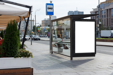 Vertical billboard at a public transport stop. Next to the summer cafe. Mock-up.