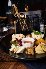 Cheese plate with grapes and honey on wooden table. Close up view
