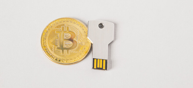 Bitkoin coin and usb key. White banner with USB flash memorry drive in the form of a key, secure cryptocurrency storage