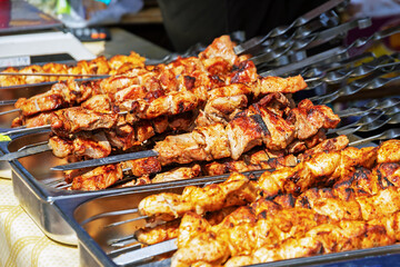 large number of juicy pork kebabs on skewers outdoors, closeup