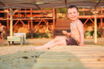 boy sitting on the beach at sunset