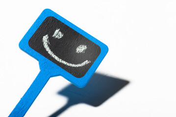 A sign with a smiley face. Blue wooden poster with a positive smile on a white background.