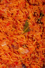 Jollof rice close-up. Background of rice cooked in tomato paste with spices.