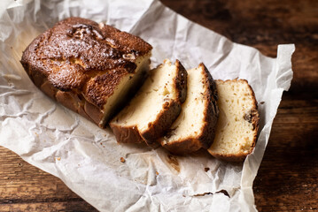 Baked banana bread. Cut into pieces. Dark wooden background. Bread with walnuts.