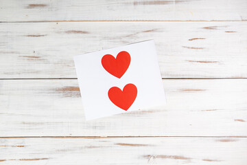 Red paper hearts printed on paper on a white wooden background. Declaration of love, valentine's day concept.