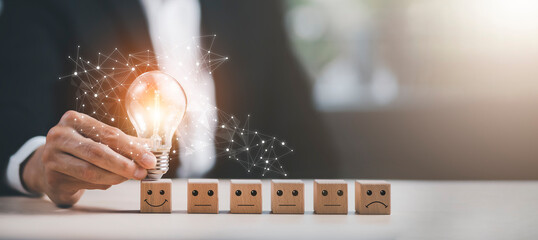 thinking and creative, Businessman hand holding light bulb on the wooden people, Teamwork and idea concept, Successful team leader, Businessman hand choose people standing out from the crowd.