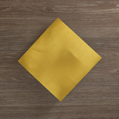 Blank gold rhomboid card on a wooden background. Text space. Top view. Minimal style.
