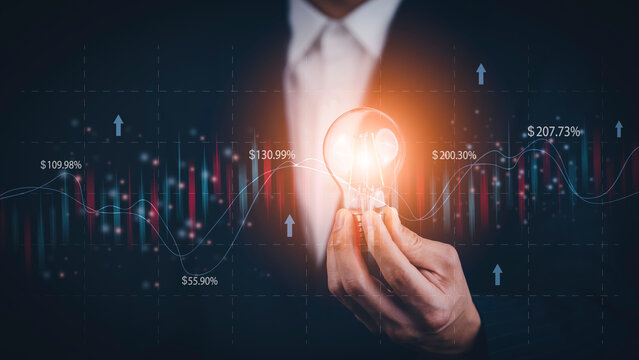 Businessman holding light bulbs, new ideas with of Stock market or forex trading graph and candlestick chart suitable for financial investment, Economy trends background for business idea stock.