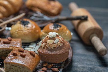 Closeup of almond muffin and assort bakery with cooking assessories on wooden table.