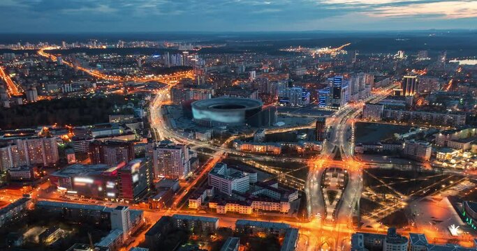 City Yekaterinburg at evening from above, hyperlapse drone view, car traffic flow. Ekaterinburg Arena stadium, aerial time lapse