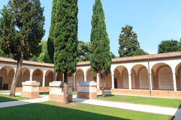 Cloistered courtyard of monastery with tombs next to church Chiesa di San Francesco in Treviso, Italy