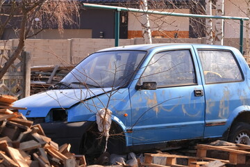 Stary, zardzewiały samochód, stojący gdzieś na podwórku. An old, rusty car somewhere in the backyard. - obrazy, fototapety, plakaty