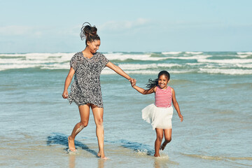 Sunny summer days are best spent at the beach. Shot of a mother and her little daughter enjoying a...