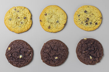 Yellow and brown homemade chocolate chip cookies on gray background top view