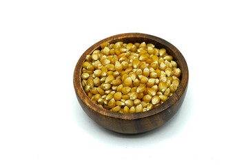 Corn kernels in wooden bowl isolated on white background