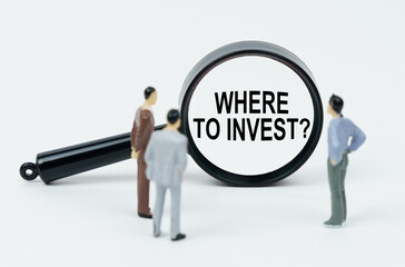 On a white background, figures of businessmen and a magnifying glass with the inscription - WHERE TO INVEST