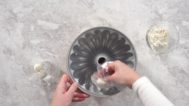 Flat lay. Step by step. Greasing bundt cake pan with vegetable shortening and sprinkling with white flour.