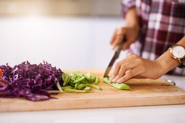 Preparing the veggies for the food. Cropped shot of an unrecognizable woman cutting vegetables in the kitchen at home.