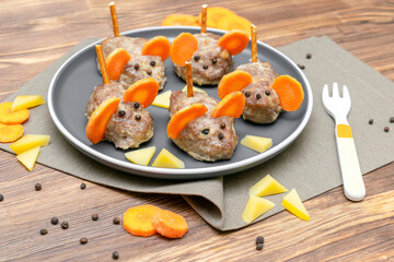 Small meatball mouse, meatloaf mice with ears of carrot, cheese on plate, creative and fun food snack idea for kids party. Menu for spooky Halloween dessert treats, edible cute rat selective focus