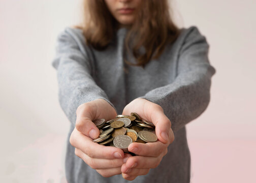 The girl holds out a full handful of Russian coins rubles