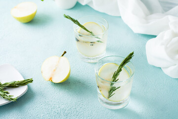 Cold cocktail of pear slices and mineral water in glasses on the table. Homemade drinks