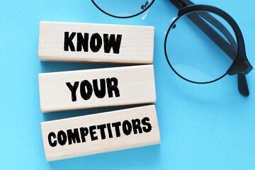  KNOW YOUR COMPETITORS text on wooden blocks, concept of business success.