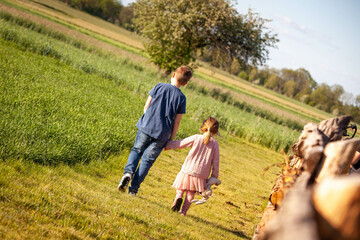 dzieci idą na spacer na polu na wsi - rodzeństwo - brat i siostra - chłopiec i dziewczynka