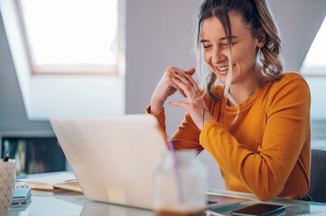 Woman having web call on a laptop while working at home