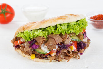 Döner Kebab Doner Kebap fast food in flatbread on a wooden board