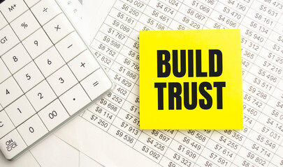 BUILD TRUST Concept. Calculator,pen and glasses on the white background
