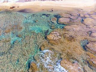Aerial view of a man alone at the beach in spring