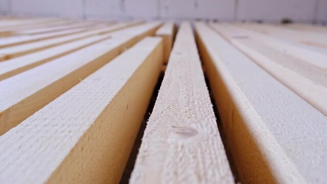Sawn boards lie on the floor parallel to each other for drying. Preparation for the installation of an eco-friendly wooden floor in a rural house. Lumber from the sawmill
