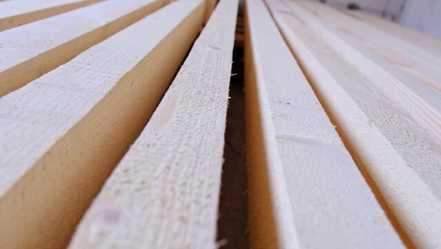 Sawn boards lie on the floor parallel to each other for drying. Preparation for the installation of an eco-friendly wooden floor in a rural house. Lumber from the sawmill