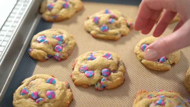 Freshly baked unicorn chocolate chip cookies on a baking sheet lined with a silicone mat.