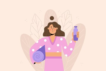 Smiling woman in a sport suit holds a yoga mat