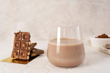 Delicious homemade cocoa drink with cocoa powder and pieces of chocolate bar.