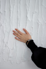 Woman's hand on a white wall. The concept of hope and ask for forgiveness.
