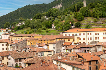 Fototapeta na wymiar View of the tiled roofs, mountains covered with trees in the town of Lovere, Lake Iseo, Italy.