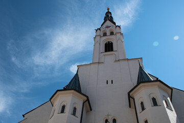 Fototapeta na wymiar Mariä Himmelfahrt Church (Assumption of Mary Church) in the Bavarian town of Bad Tölz in Germany, seen from below, with the clock tower looking like a face