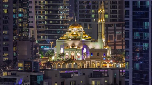 Dubai Marina skyline with Mohammad Bin Ahmed Al Mulla mosque aerial timelapse at night.