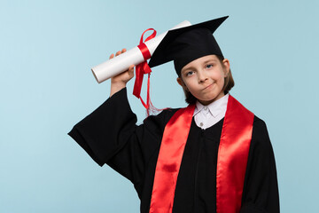 Whizz kid 9-11 year girl wearing graduation cap and ceremony robe with certificate diploma on light...